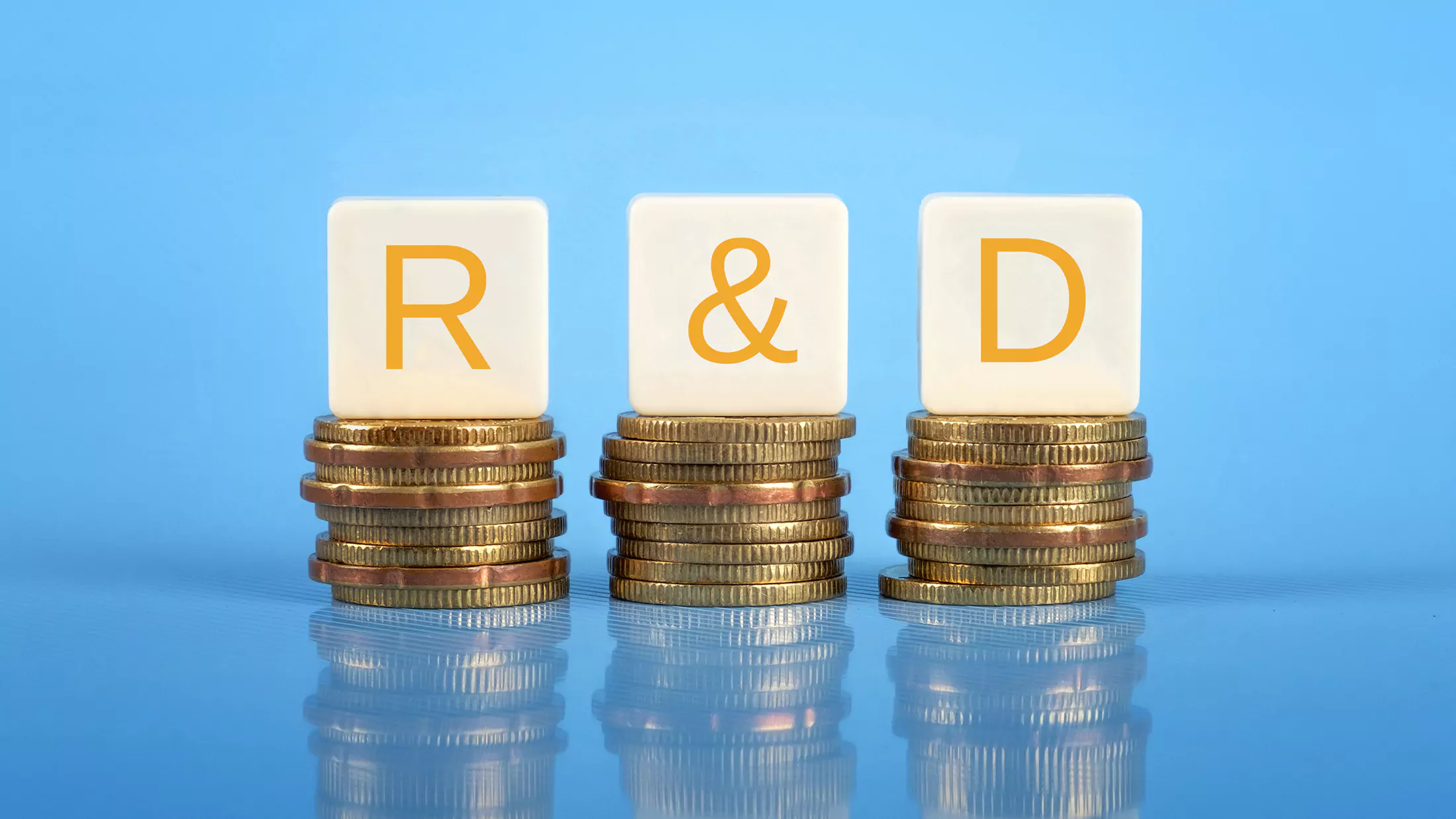 Letters for R ampersand D on three adjacent stacks of coins.
